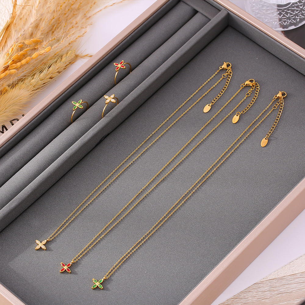 Niche four-petaled flower inlaid zircon pendant, collarbone necklace, open ring, titanium steel plated 18k real gold set, women's 99.