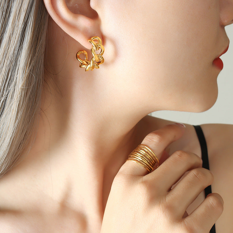 Cold wind niche fashion twist hollow C-shaped earrings titanium steel plated 18K gold stud earrings F322