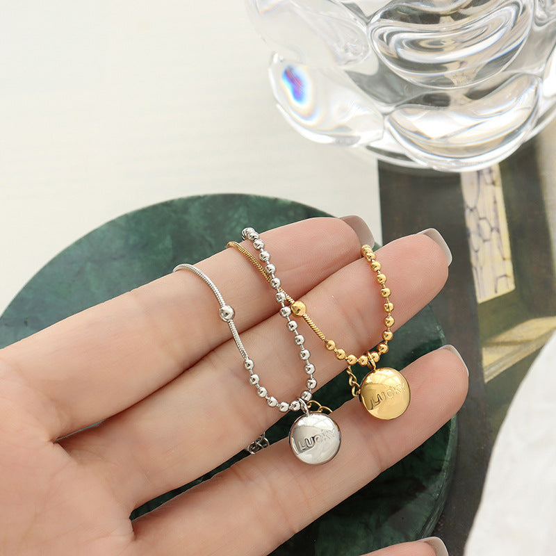 Fashion commuter letter engraving round brand pendant bracelet niche design titanium steel gold-plated round bead splicing